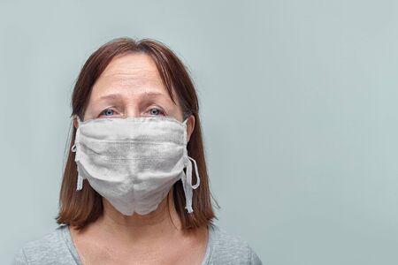 Old woman wearing a mask fear problem air pollution on a white background, healthcare concept.の写真素材