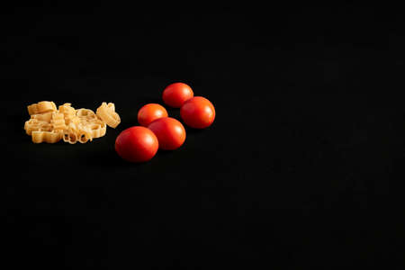 Kit for the preparation of spaghetti on black background with pasta,tomatoes