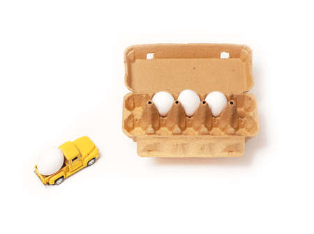 Egg in toy car on a white background