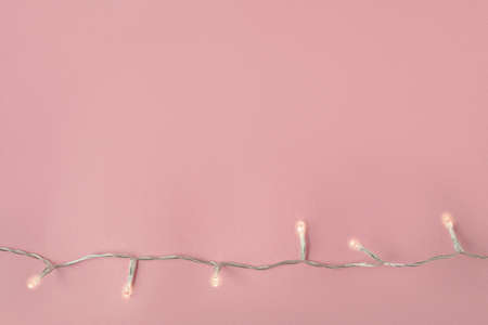 New Years garland with lights on a pink background