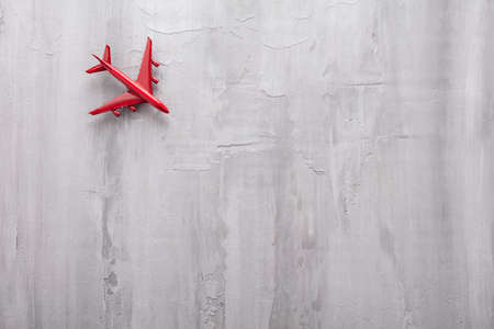 Red passenger toy plane on a gray background. Vacation concept
