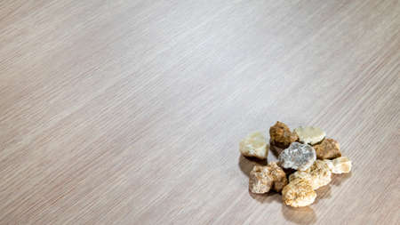 Different colored small stones on light brown table