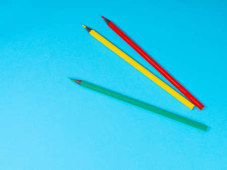 Red, Yellow and Green Colored Pencils on Blue Background. Office supplies, education concept. Back to schoolの写真素材