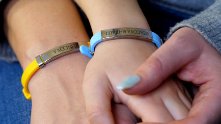 Mother and daughter hand with vaccined label or bracelet after injection. Prevention precaution to preserve health. Coronavirus COVID-19 pandemic concept. Vaccination to boost immunityの写真素材