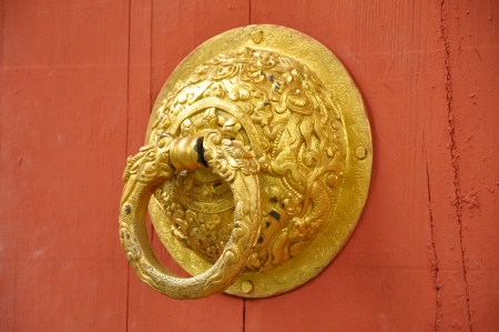 Golden door handle on a red door.の写真素材