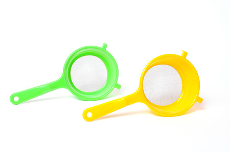 Yellow and Green handle colander isolated on white backgroundの写真素材