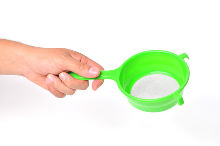 Green handle colander in hand isolated on white backgroundの写真素材