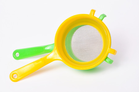 Yellow and Green handle colander isolated on white backgroundの写真素材