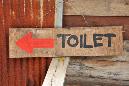 Signs to the toilets, which was written on a sheet of plywood.の写真素材