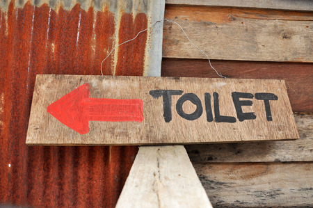 Signs to the toilets, which was written on a sheet of plywood.の写真素材