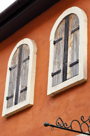 European style wooden windows, rounded corners on the brown wall.の写真素材