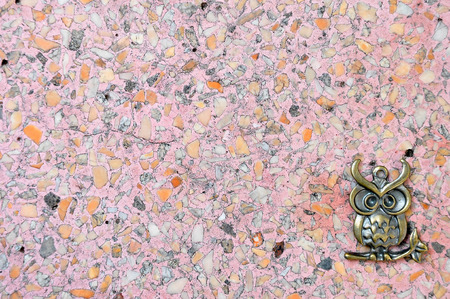 metal owl isolated at corner on pink terrazzo floor backgrkoundの写真素材