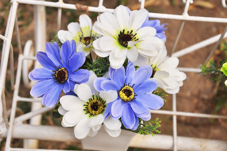 Blue and white plastic flowers in a vase.の写真素材