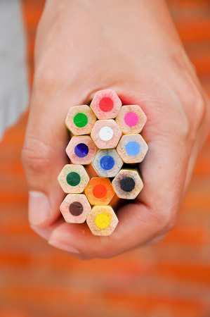 A brightly colored pencils in her handful.の写真素材