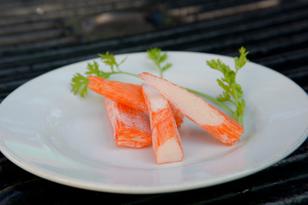 Surimi on a black plate decorated with parsley.の写真素材