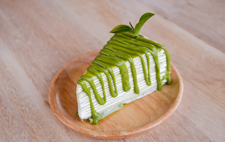 Crepe cake flavored green tea on a wooden plate.の写真素材