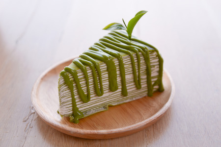 Crepe cake flavored green tea on a wooden plate.の写真素材