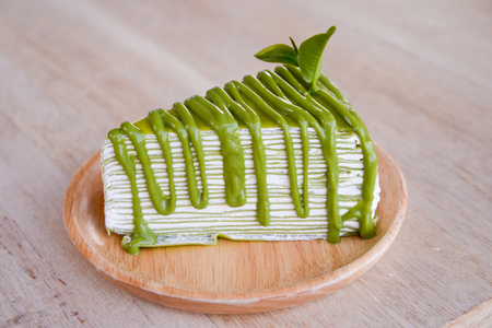 Crepe cake flavored green tea on a wooden plate.の写真素材