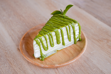 Crepe cake flavored green tea on a wooden plate.の写真素材