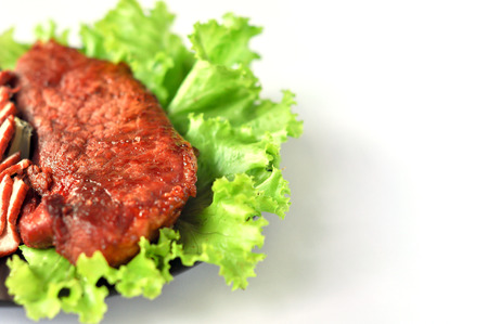 Roasted red pork on a green salad in a black plate.の写真素材