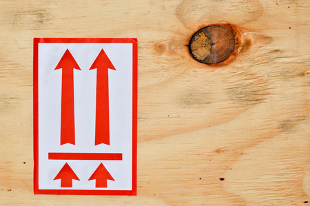 red arrow on plywood, it's a symbol that means to take up the top.の写真素材