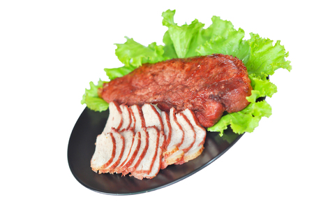 Roasted red pork on a green salad in a black plate.の写真素材