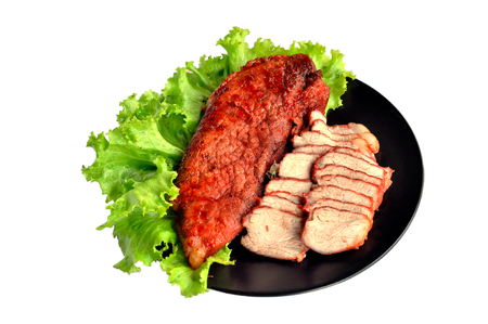 Roasted red pork on a green salad in a black plate.の写真素材