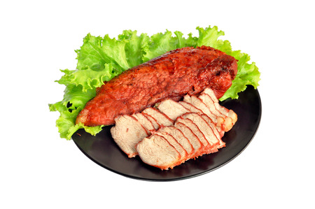 Roasted red pork on a green salad in a black plate.の写真素材