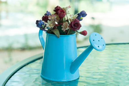 A little artificial flowers in a little watering canの写真素材