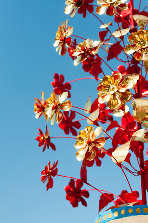 Golden and red artificial flowers on sky backgroundの写真素材