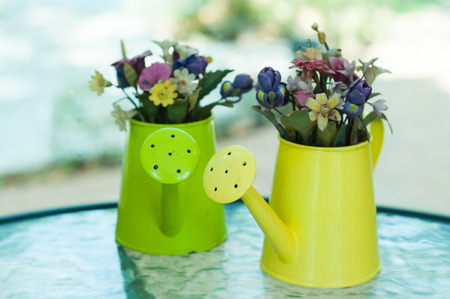 A little artificial flowers in a little watering canの写真素材