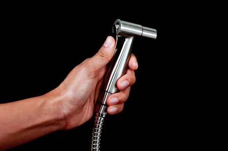 bidet shower in hand  isolated on black backgroundの写真素材