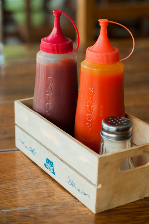 Ketchup and chilli sauce in small wooden boxの写真素材
