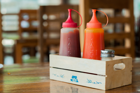 Ketchup and chilli sauce in small wooden boxの写真素材