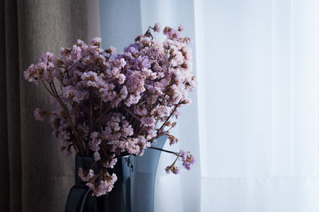 Dry purple flowers placed near window
