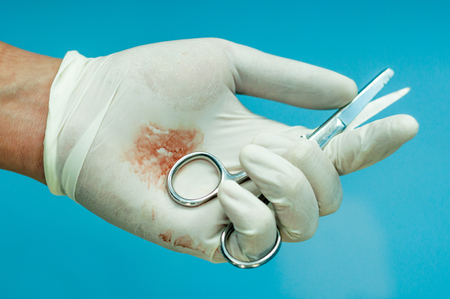 Operating Scissor in hand stained with blood.の写真素材