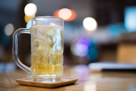Beer in a glass on a bar under the bokeh light.の写真素材