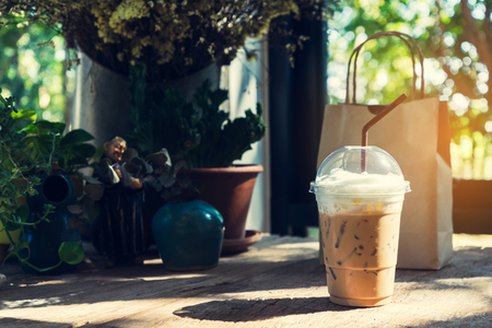 Iced cappuccino on the wooden table at the corner of the coffee shop, with light from the sun. in vintage styleの写真素材