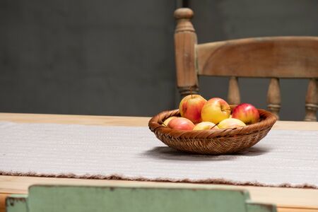 Fresh apples in the basket are placed on the dining table to welcome guests.の写真素材