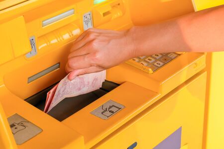 Withdraw money from an automated teller machineの写真素材