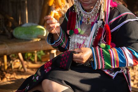 The Akha woman is sewing her clothesの写真素材