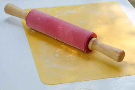 Fuchsia rolling pin on a yellow padの写真素材