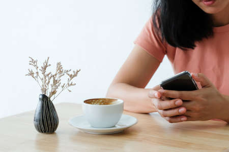 Woman holding smart phone during coffee time in the morning.の写真素材