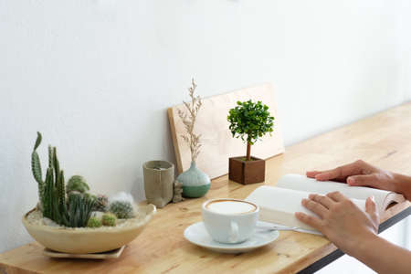 Mockup image of a woman reading a book on table with blank pages of bookの写真素材
