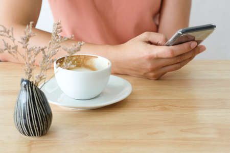 Woman holding smart phone during coffee time in the morning.の写真素材