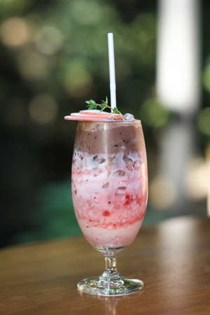 The iced strawberry drink is topped with a chocolate smoothie.の写真素材