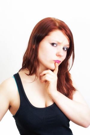 Brunette woman in black is thinking on white backgroundの写真素材