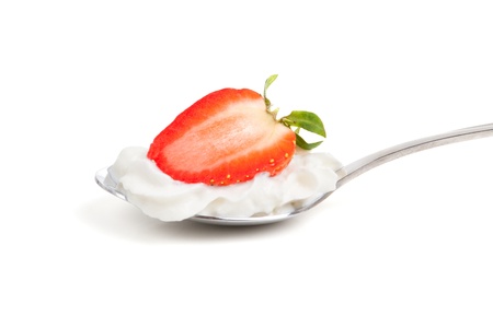 a half strawberry in whipped cream on an spoonの写真素材