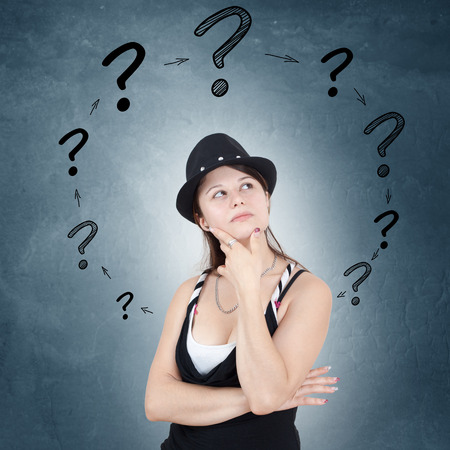Young woman with drawn question marks circulating around her head