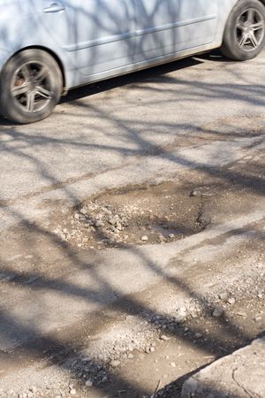 Asphalt`s hole on roadbed. Car in a motion.の写真素材